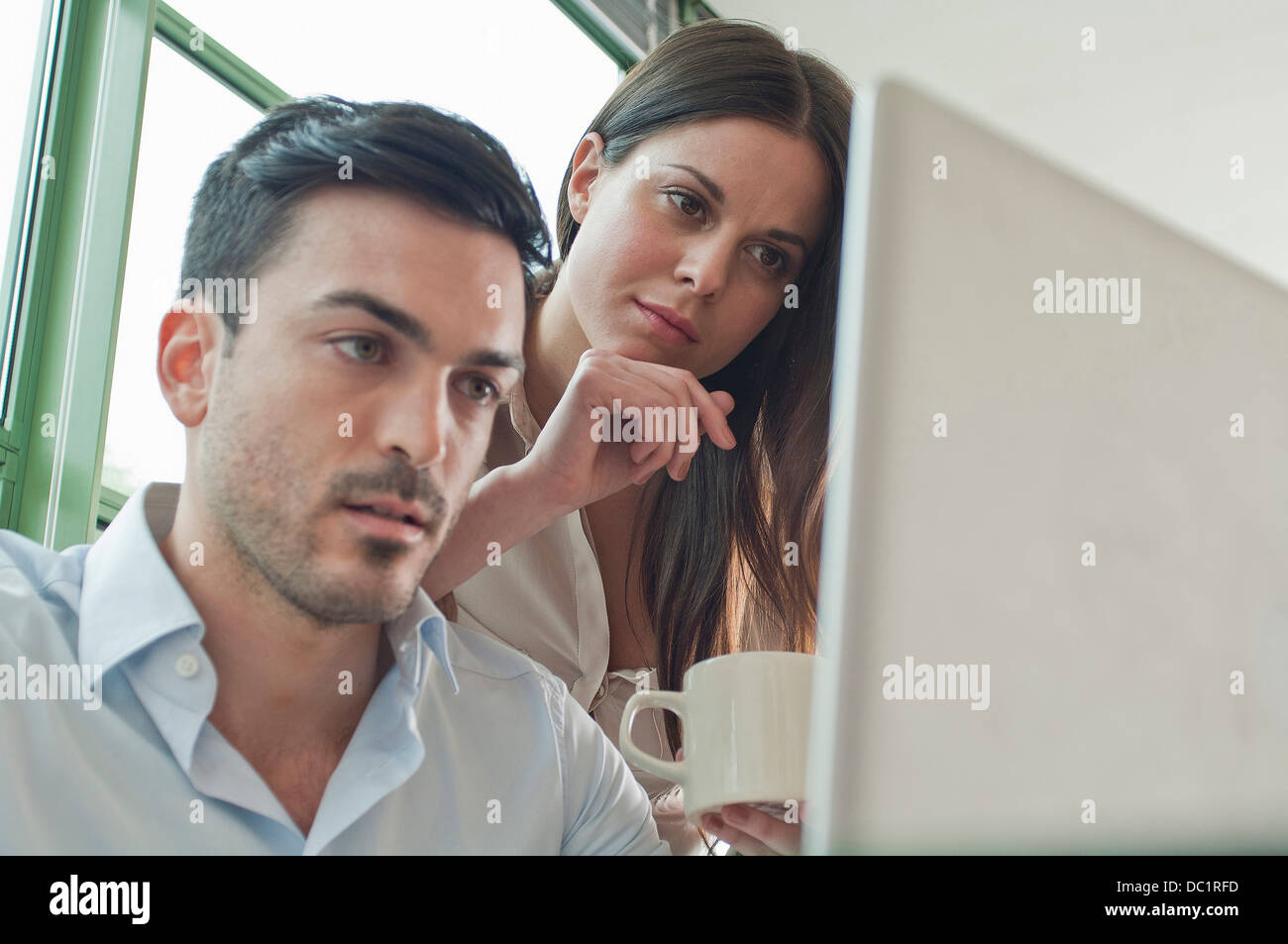 Junge Büroangestellte Blick auf laptop Stockfoto