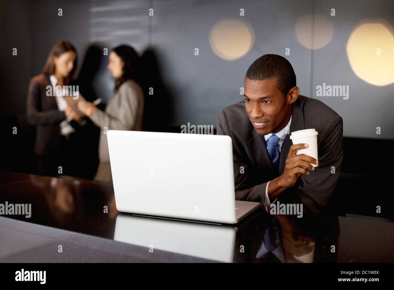Lächelnd Geschäftsmann Kaffee zu trinken und mit laptop Stockfoto
