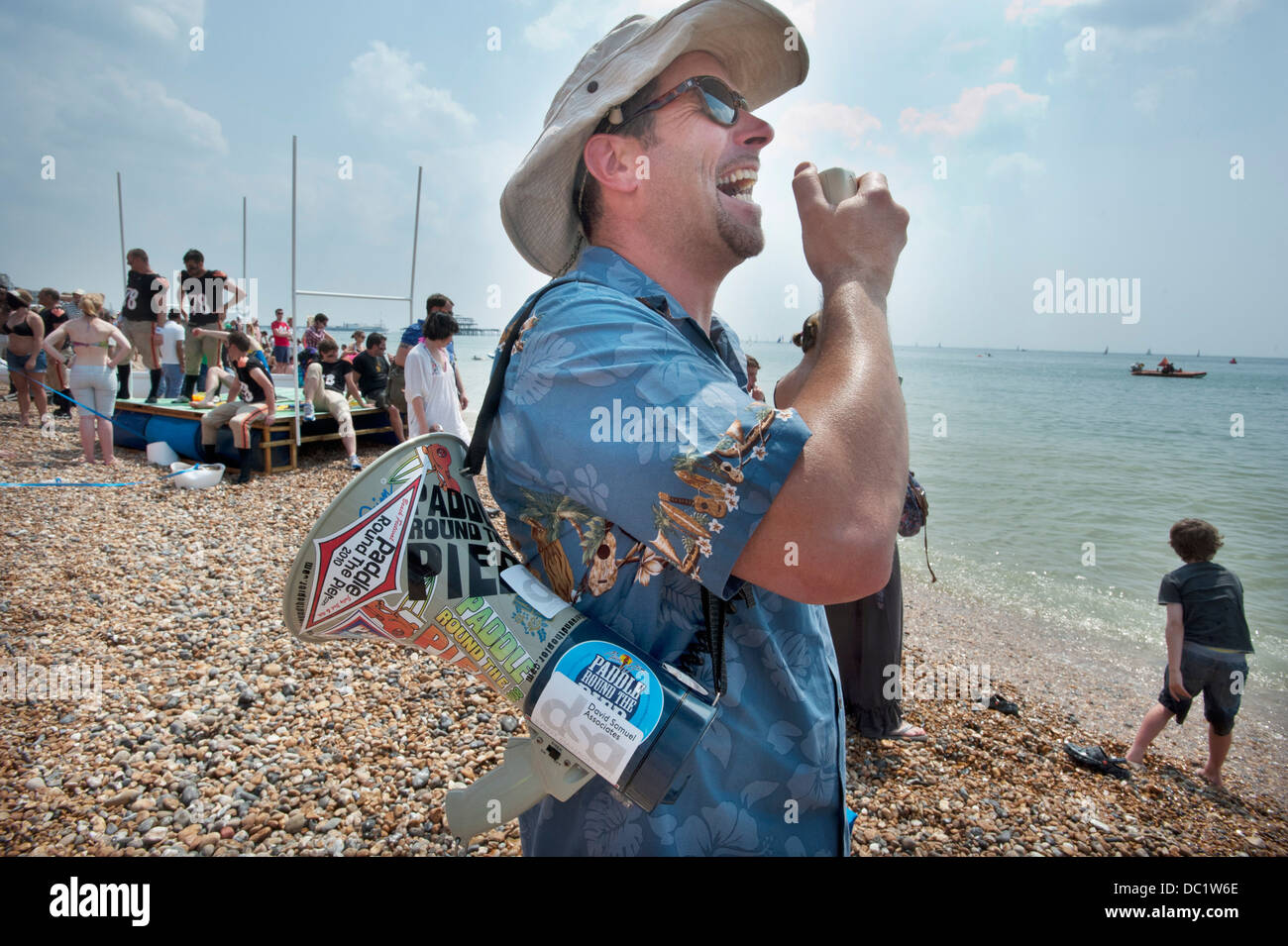 Ein Padddle Round The Pier Strand Festival Veranstalter bei Brighton UK schreien Ermutigung auf sein Megaphon. Stockfoto