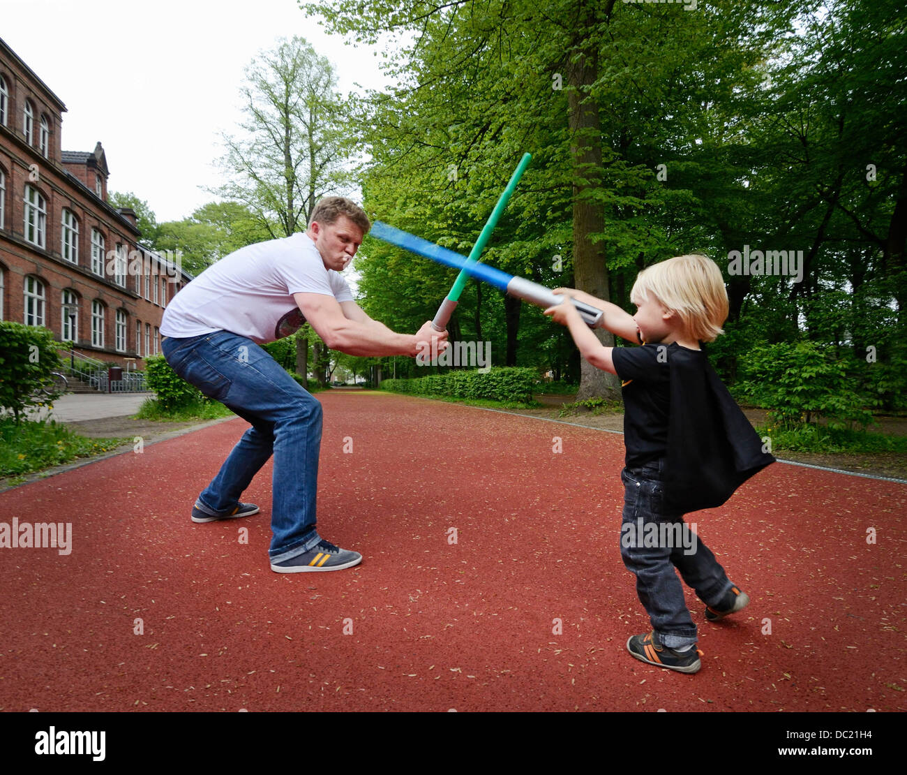 Vater und Sohn spielen mit Spielzeug Schwerter kämpfen Stockfoto