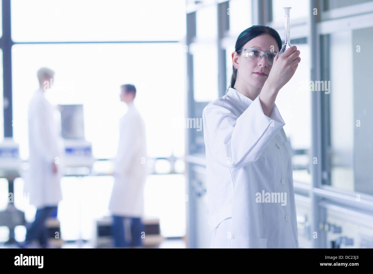 Chemie-Student auf der Suche auf Kolben im Labor Stockfoto