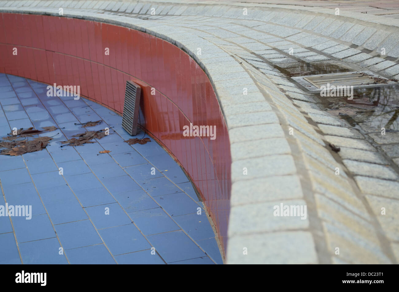 Leere nass vor-und Nachsaison schwimmen Pool mit Kanal decken und Blätter Stockfoto