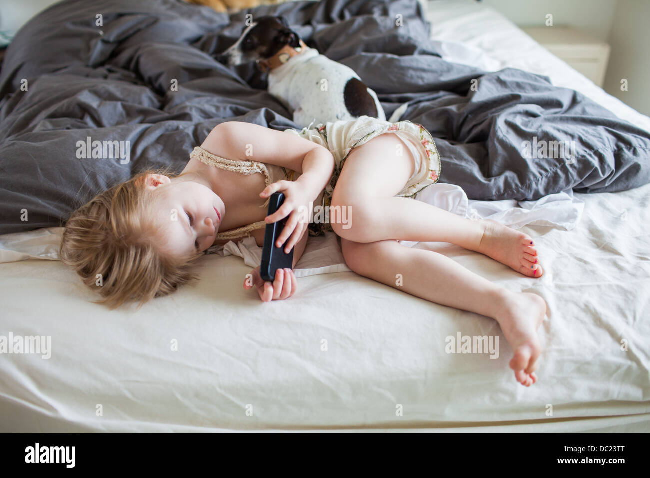 Mädchen auf Bett mit smartphone Stockfoto