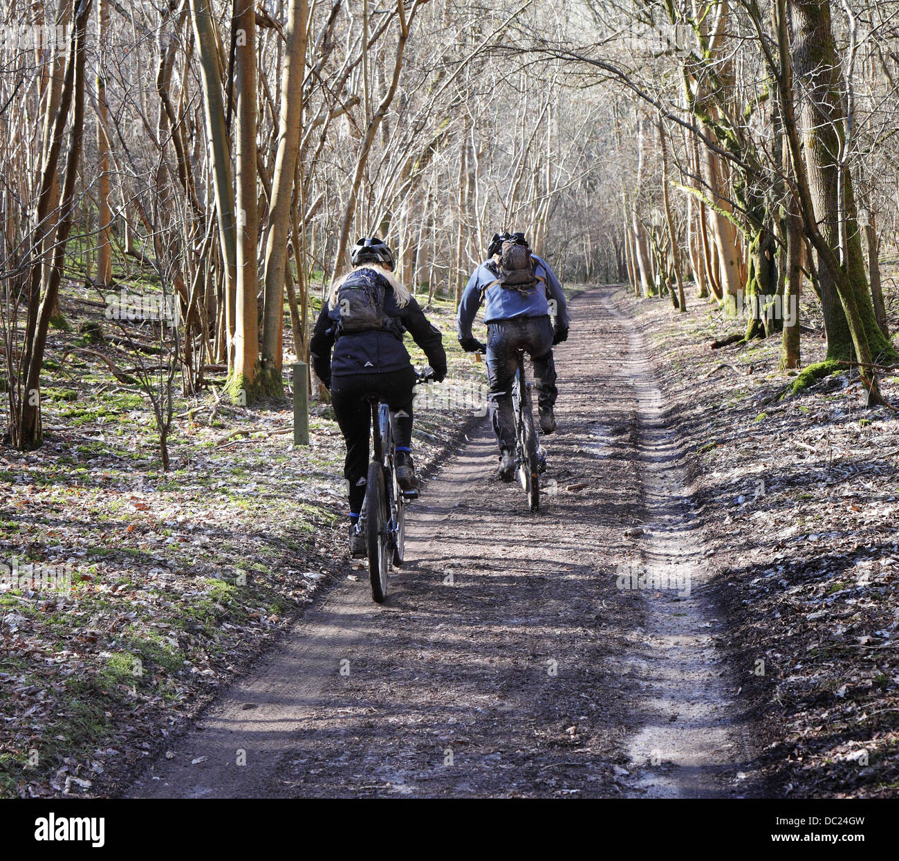 Männliche und weibliche Radfahrer auf einem englischen ländlichen Weg im Winter Stockfoto