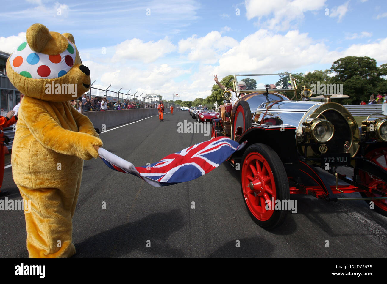 BBC-Kinder in Not Pudsey Wellen Chris Evans aus in seinem Chitty Chitty Bang Bang Film Auto bei CarFest North, Oulton Park. Stockfoto
