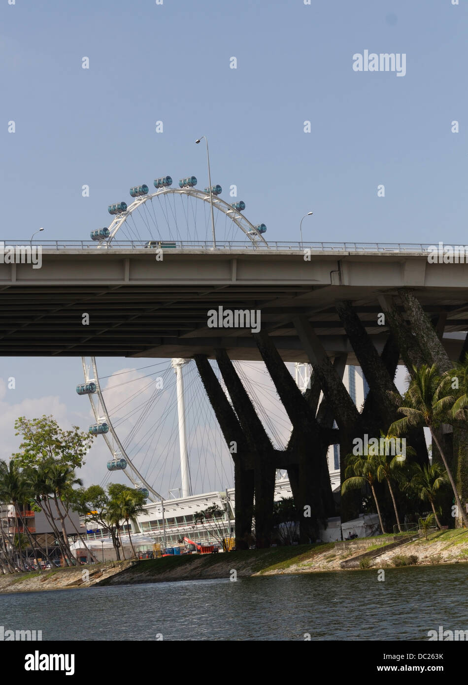 Spannweite der Benjamin Sheares Bridge mit den Säulen in Singapur und das Rad der Singapore Flyer. Wasserbehälter unten. Stockfoto