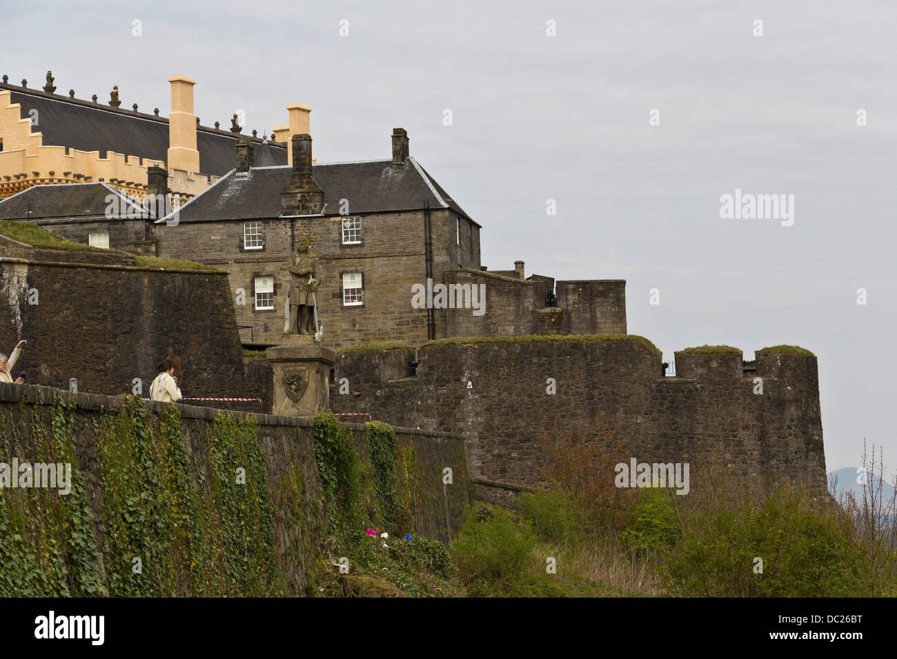 Statue von Robert Bruce und die Struktur von Stirling Castle auf dem Hügel. Die Wände des Schlosses haben Schlingpflanzen auf sie. Stockfoto