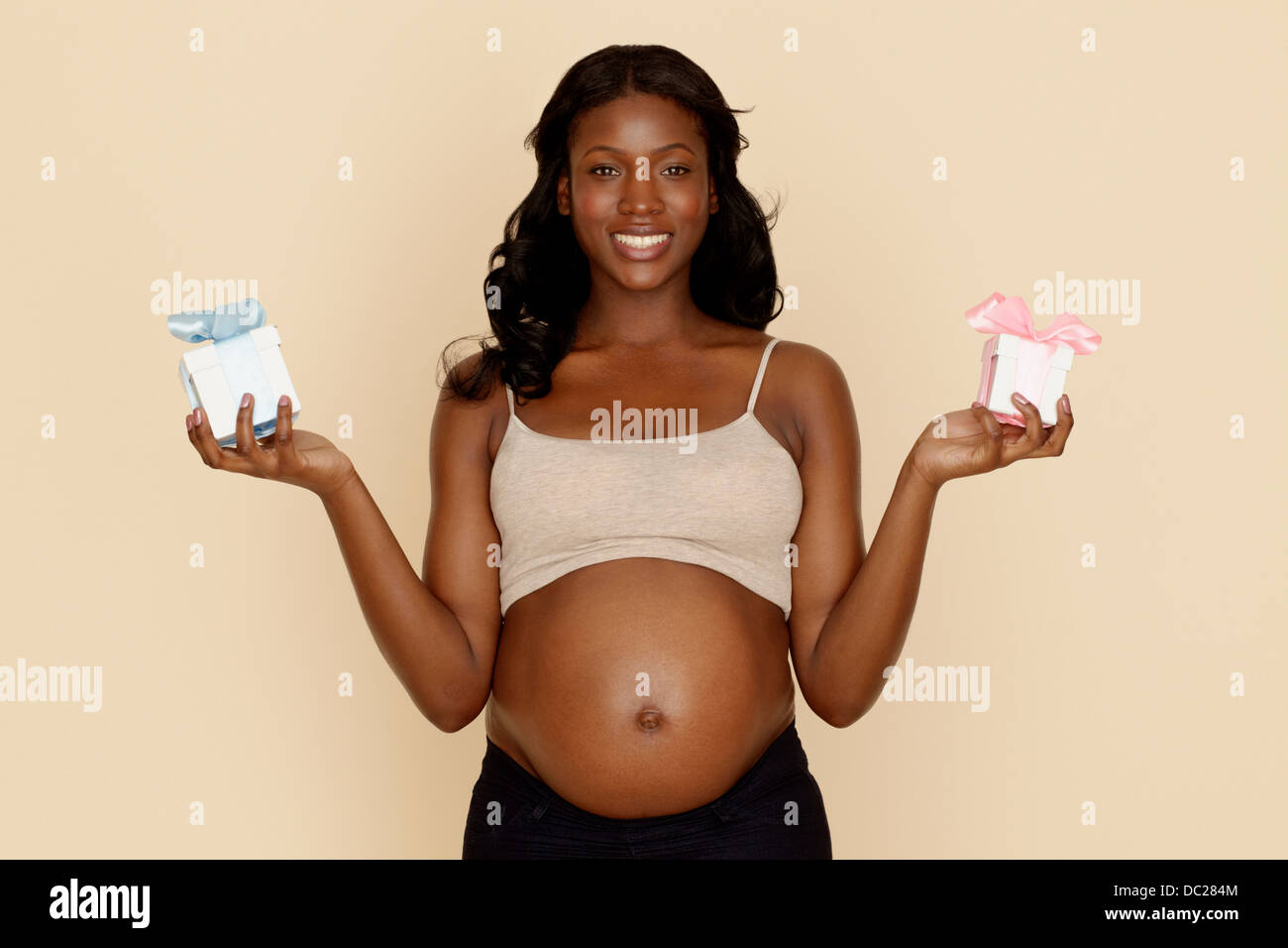 Schwangere junge Frau mit blau und Rosa Geschenk-Boxen Stockfoto