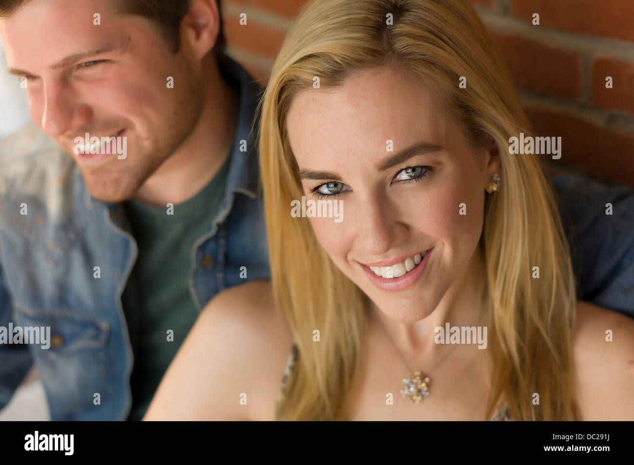 Porträt des Paares, lächelnde junge Frau im Mittelpunkt Stockfoto