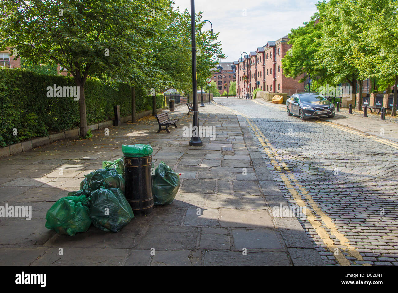 Müll Taschen voller Wurf von bin warten gesammelt werden. Castlefield, Manchester. Stockfoto