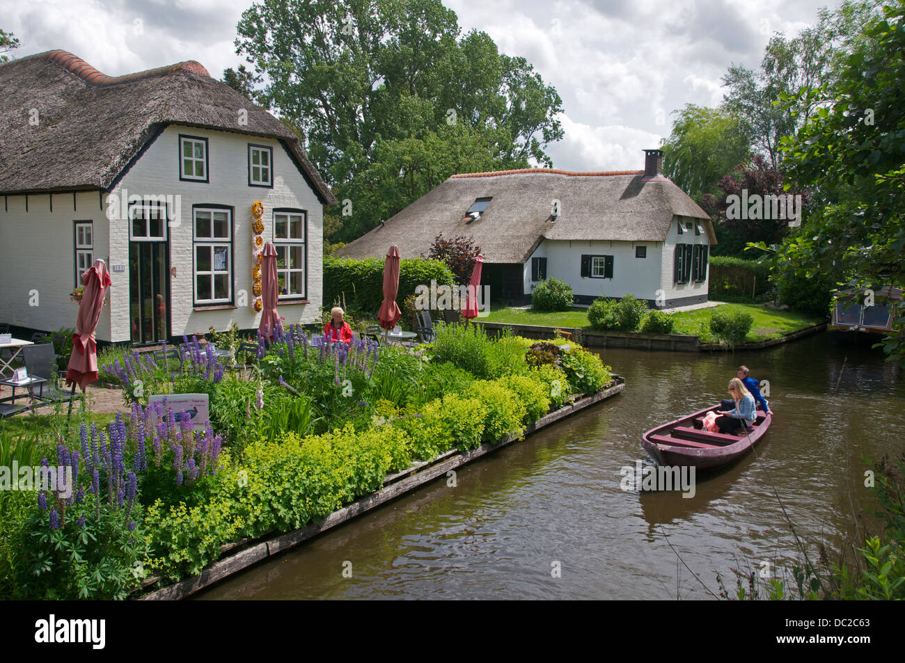 Grachtenhäuser und Touristen im Boot Giethoorn Holland Stockfotografie