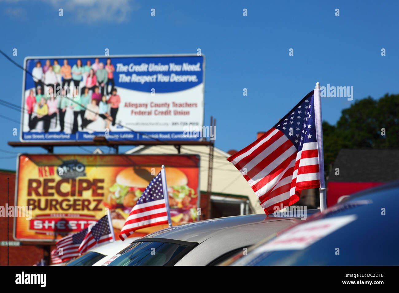 Amerikanische Fahnen auf nagelneuen Autos n vor Rezept Burgerz und Allegany County Lehrer Federal Credit Union Plakatwände, Cumberland, Maryland, USA Stockfoto