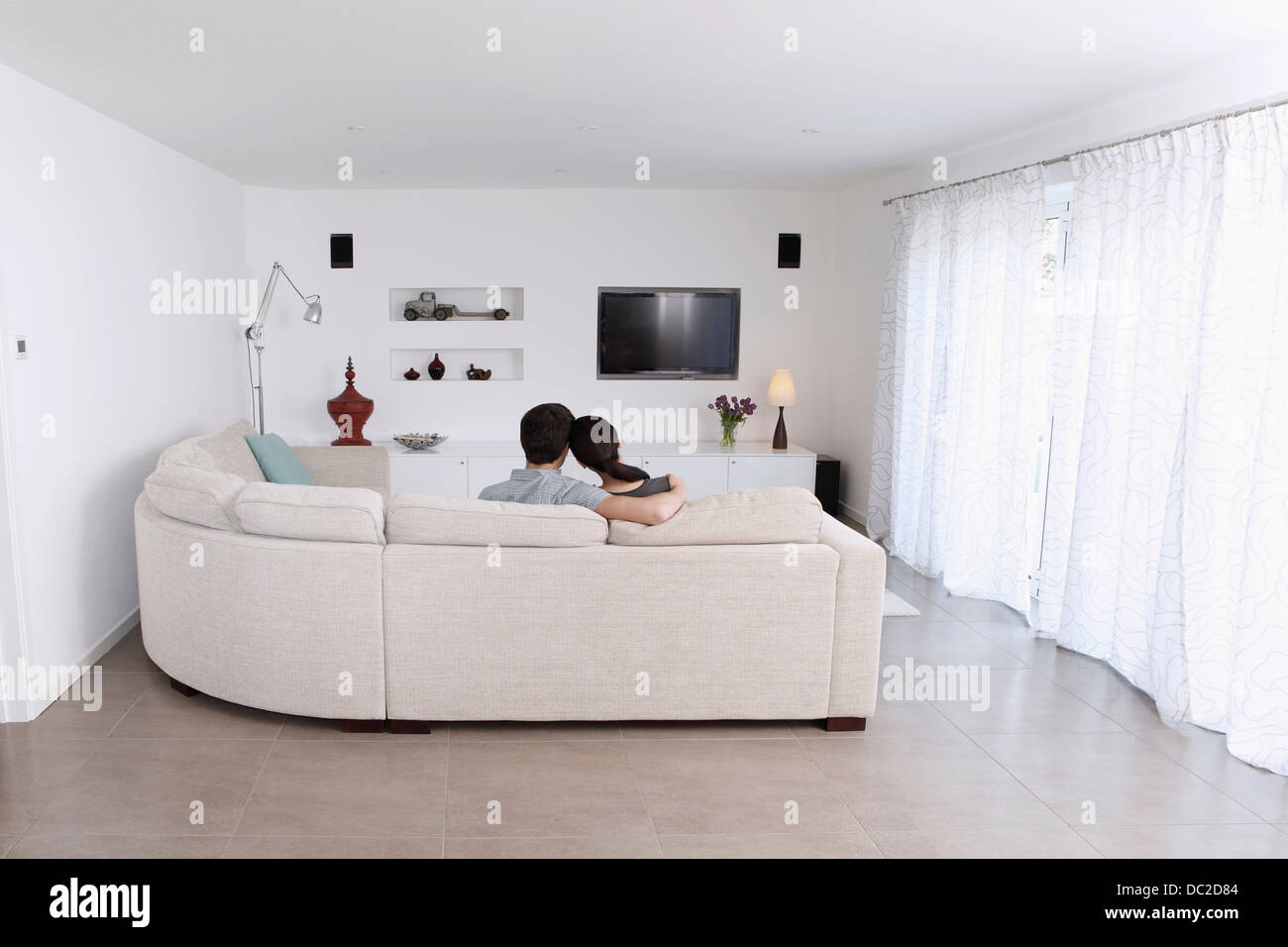 Mann und Frau auf Ecksofa im Wohnzimmer entspannen Stockfoto