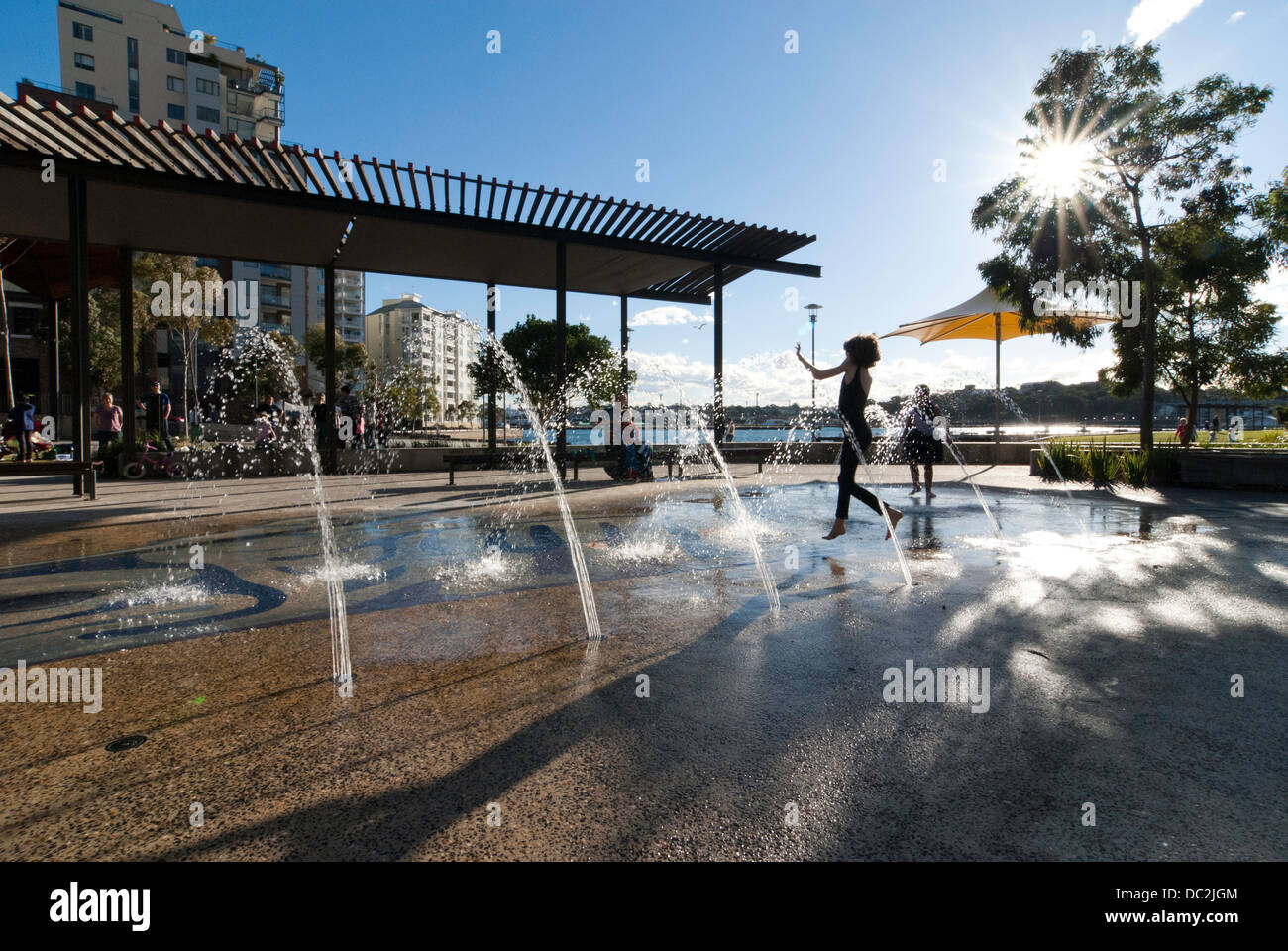 Junge Mädchen durch Wasser laufen jets am Pirrama Park, Pyrmont, Sydney Stockfoto