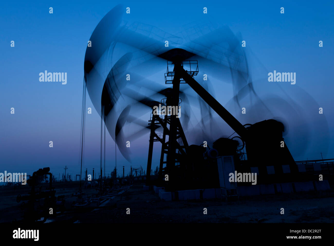 arbeiten Öl Pumpe Silhouette in der Abenddämmerung Stockfoto