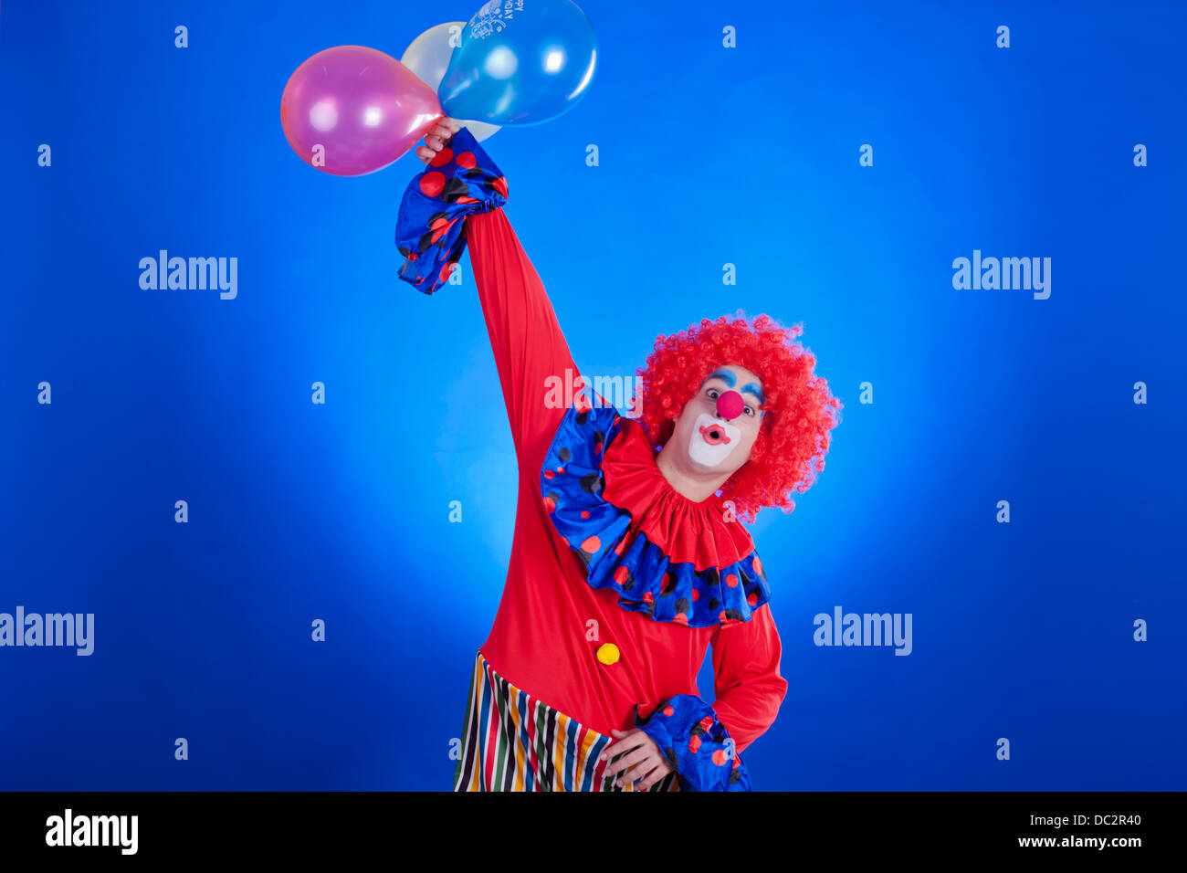 Happy Clown mit Ballons auf blauem Hintergrund Studio in Schuss Stockfoto