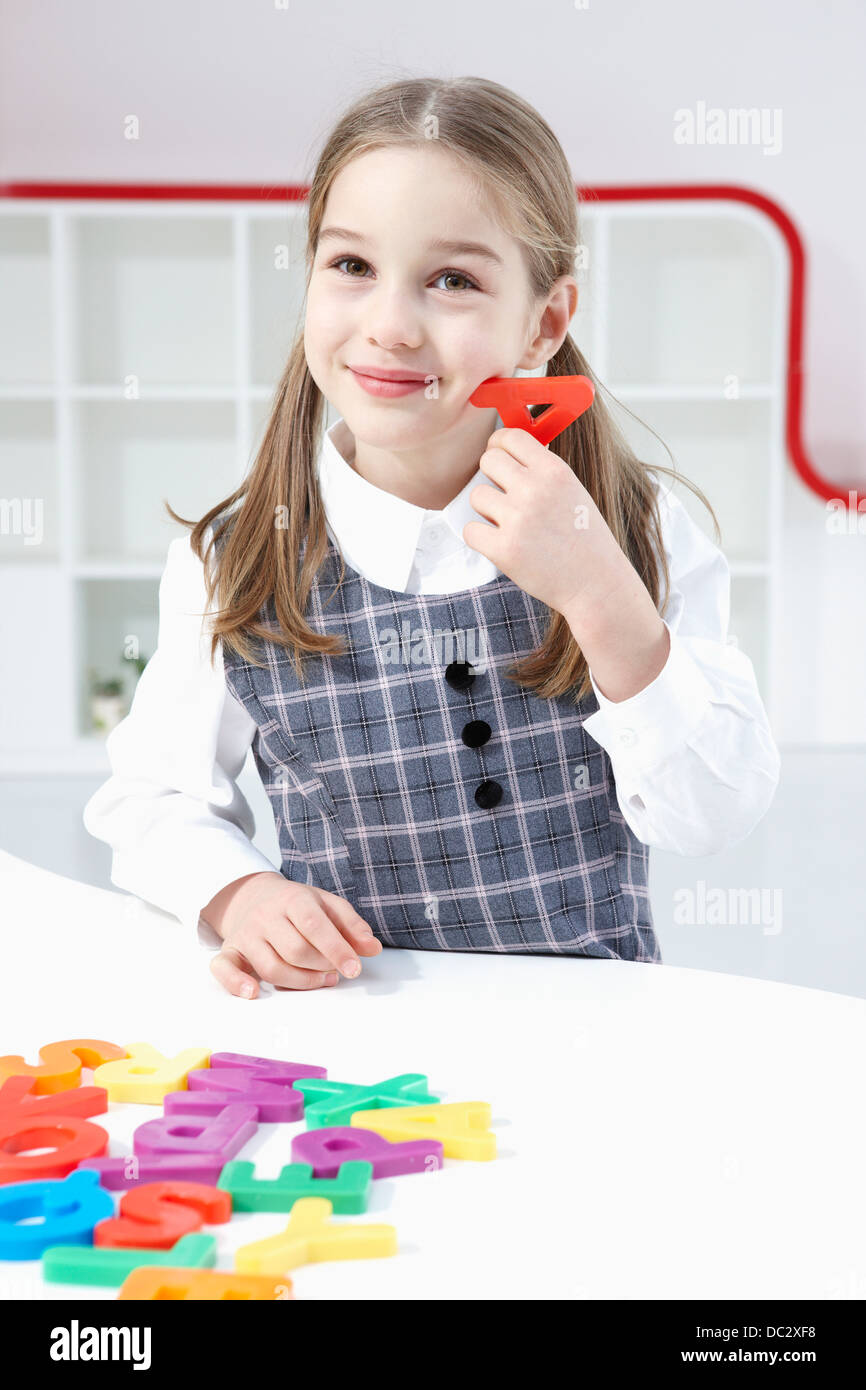 ein Mädchen mit einem roten block eine alphabet Stockfoto