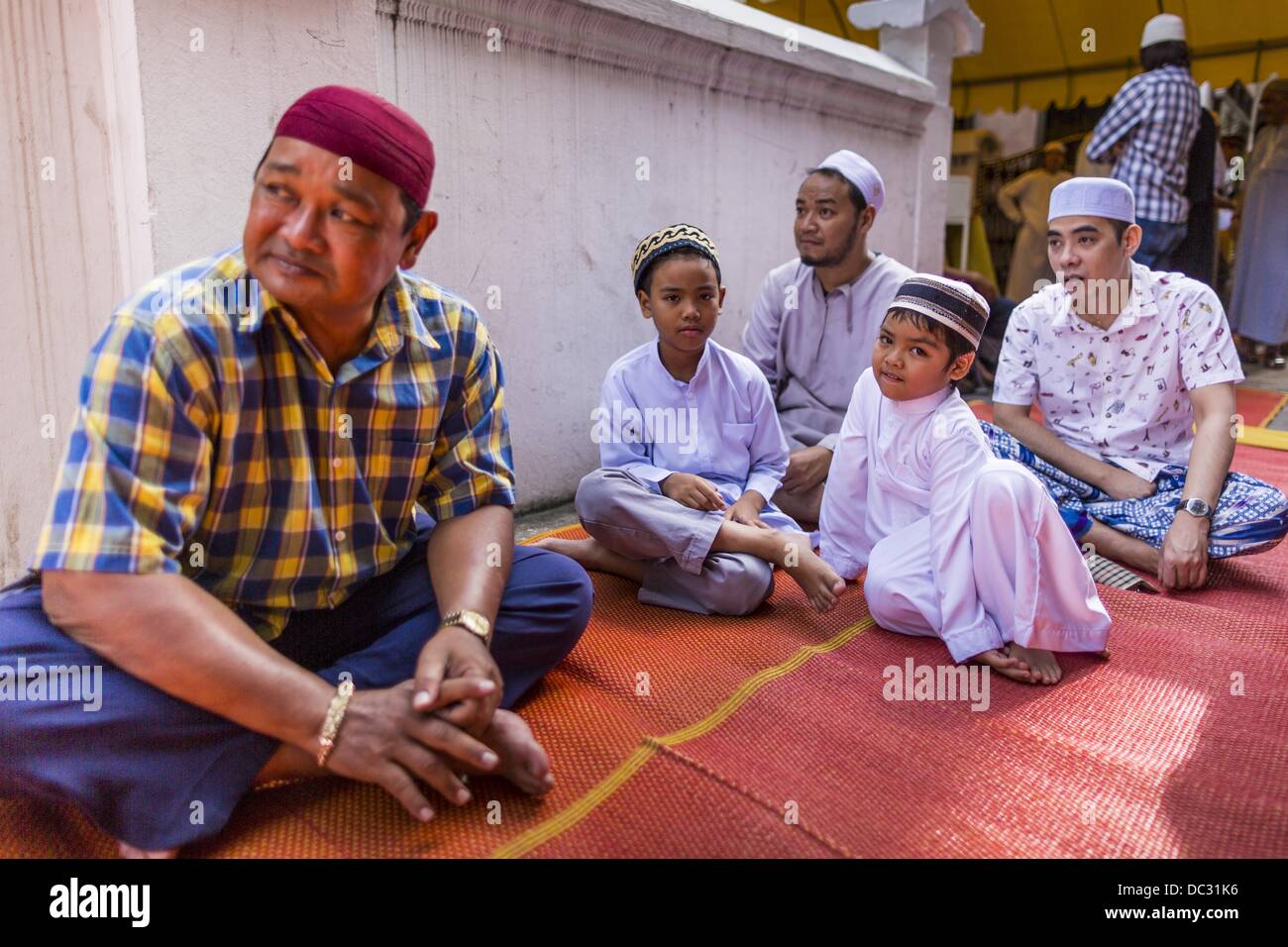 Bangkok, Thailand. 8. August 2013. Männer und jungen warten außerhalb Haroon Moschee für Eid-Services zu starten. Eid al-Fitr ist '' Festival brechen des Fastens,'' es nennt auch die geringeren Eid. Es ist ein wichtiger religiöser Feiertag von Moslems weltweit gefeiert, der markiert das Ende des Ramadan, der islamische heilige Monat des Fastens. Die religiösen Eid ist ein Tag und Muslime sind nicht gestattet, an diesem Tag zu fasten. Bildnachweis: ZUMA Press, Inc./Alamy Live-Nachrichten Stockfoto