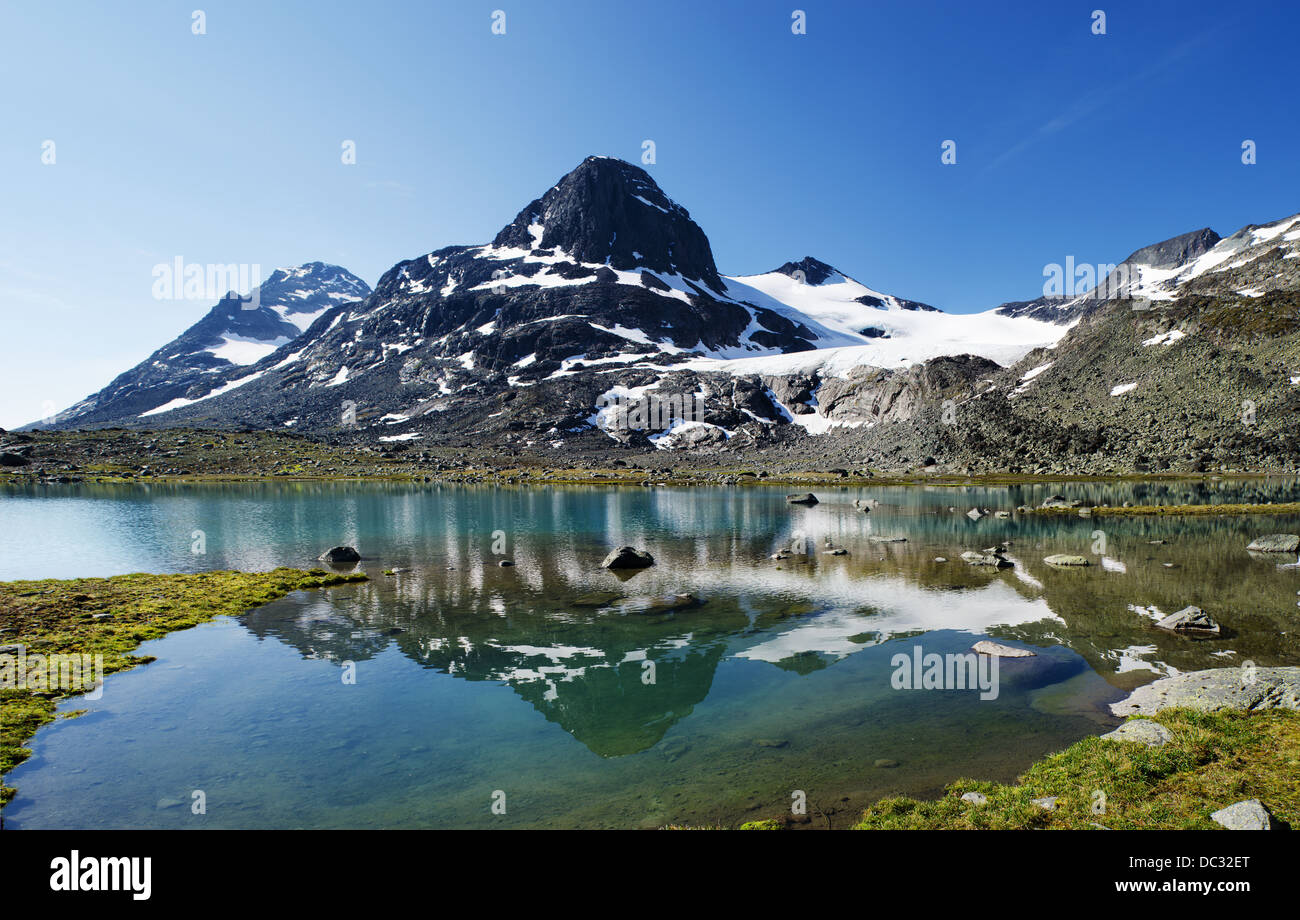 Kleiner See im Jotunheimen Nationalpark in Norwegen. Der Berg spiegelt sich im Wasser. Photomerge vier Schüsse. Stockfoto