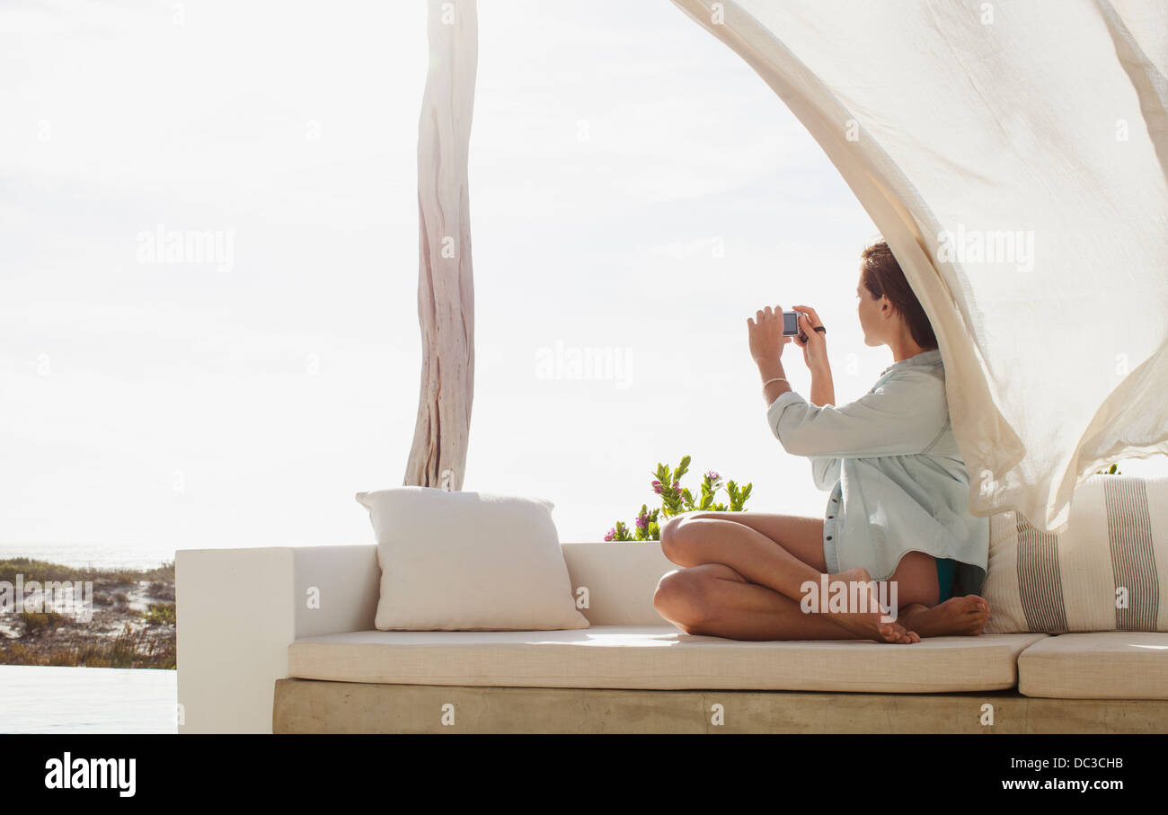 Frau nehmen Foto auf sonnigen Terrasse Stockfoto