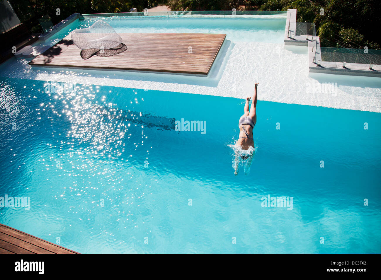 Frau im Luxus-Schwimmbad tauchen Stockfoto
