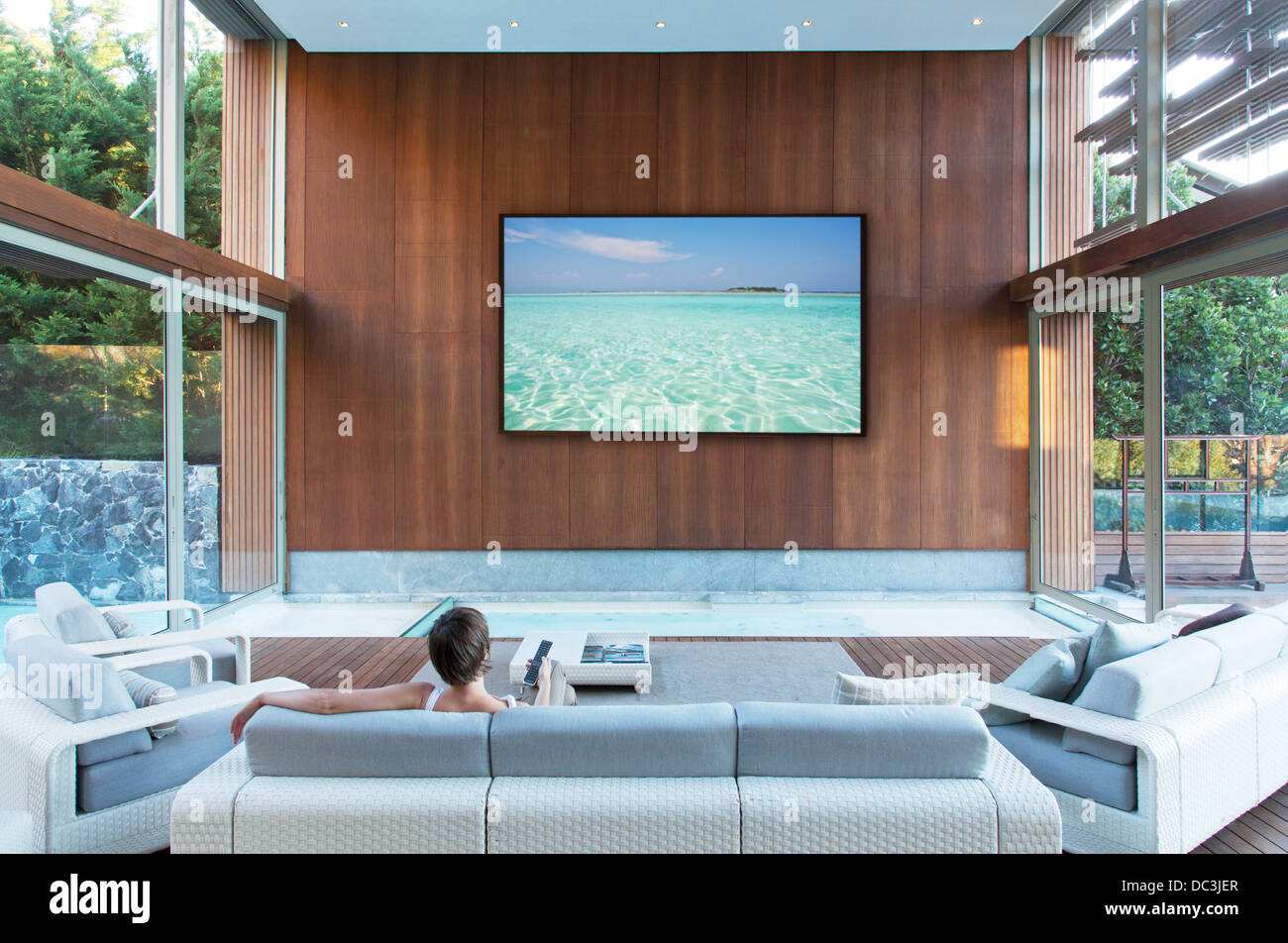 Frau vor dem großen Flachbild-Fernseher in moderne Wohnzimmer Stockfoto