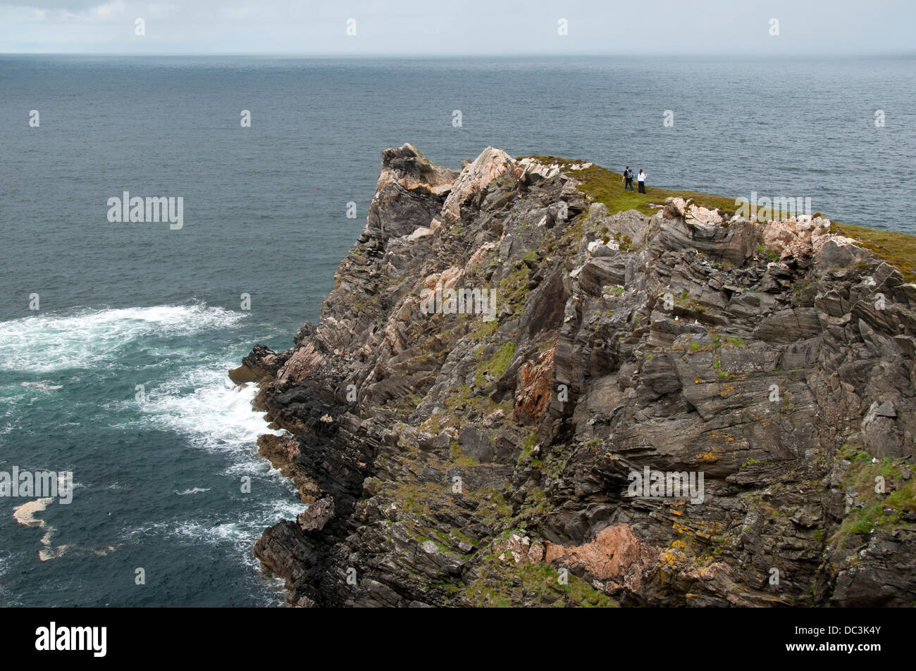 Wanderer auf einem schmalen Grat am Rande einer Geo auf Klippen in der Nähe von Skerray auf der nördlichen Küste von Sutherland, Schottland, UK. Stockfoto