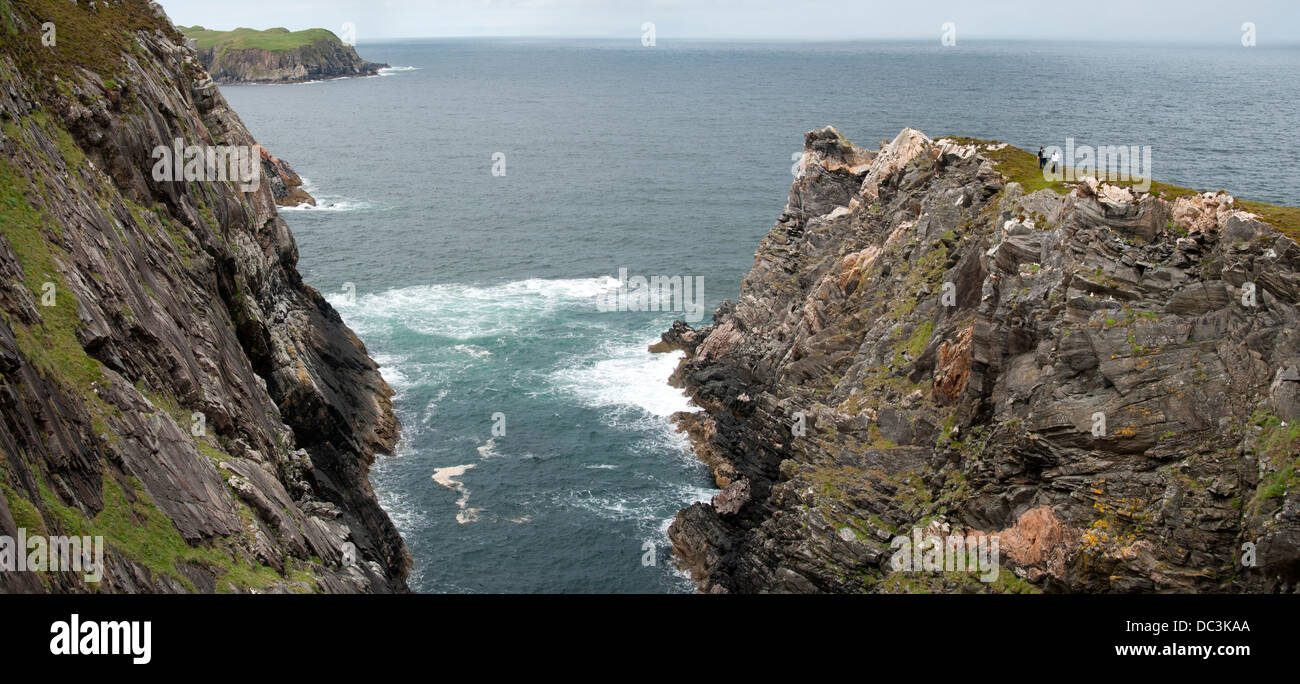Wanderer auf einem schmalen Grat am Rande einer Geo auf Klippen in der Nähe von Skerray auf der nördlichen Küste von Sutherland, Schottland, UK. Stockfoto