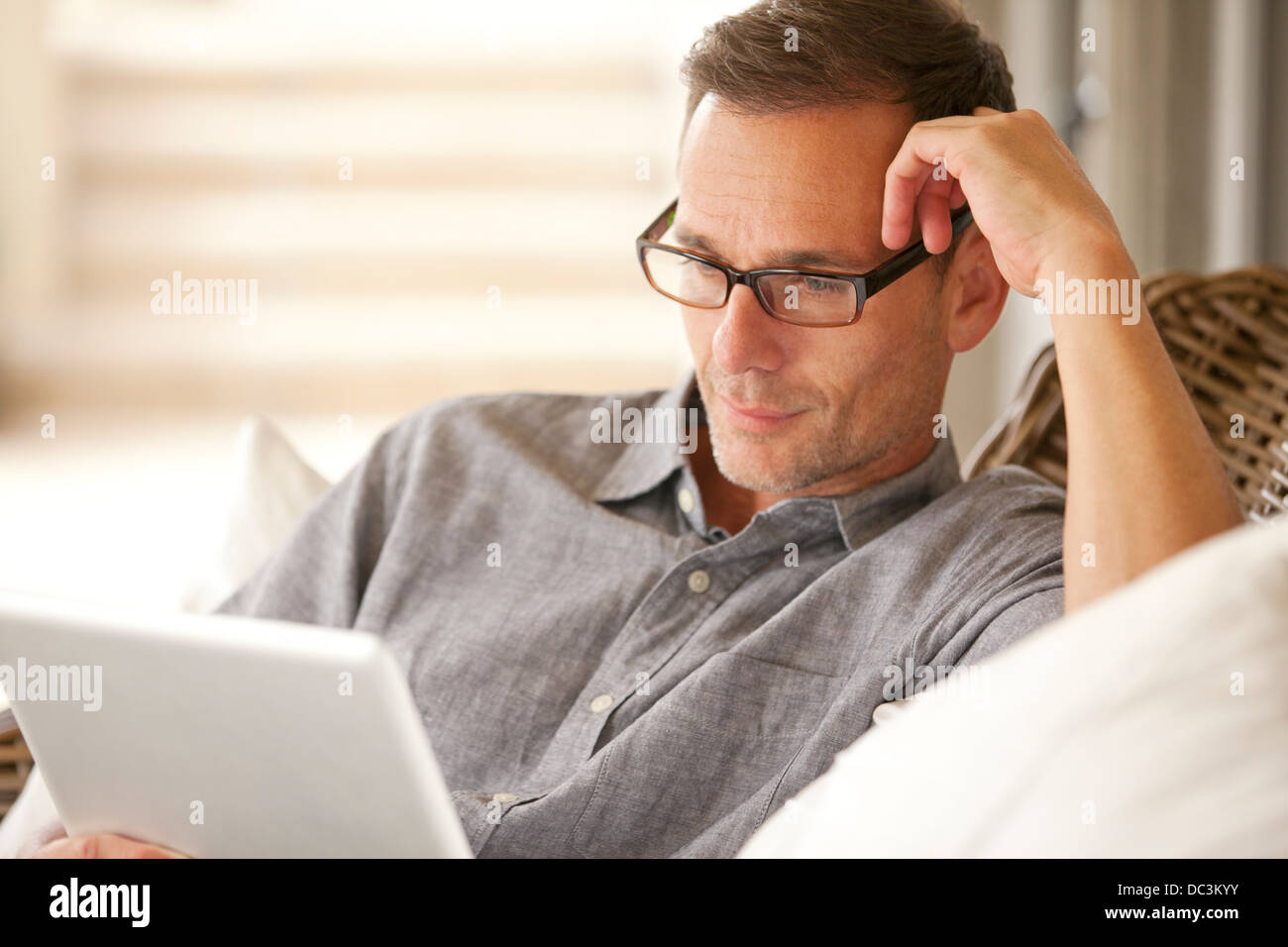 Nachdenklicher Mann mit digital-Tablette Stockfoto