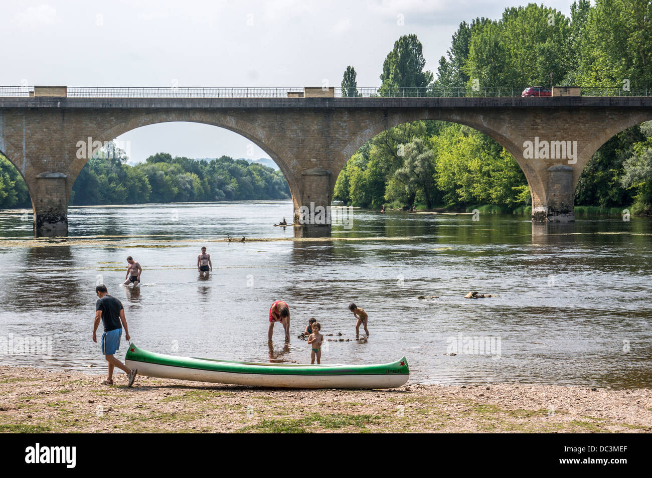 Badesee und dem Menschen ziehen ein Kanu in der Nähe der Brücke in Limeuil, die sich dort befinden, wo die Flüsse Dordogne und Vézère, South West France. Stockfoto