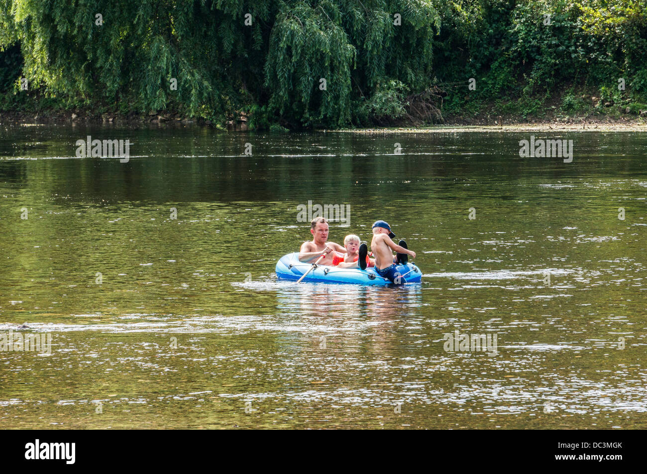 Einem Vater und seinen zwei Kindern in ein aufblasbares Boot auf dem Fluss in Limeuil, wo die Flüsse Dordogne und Vézère, im Südwesten Frankreichs. Stockfoto