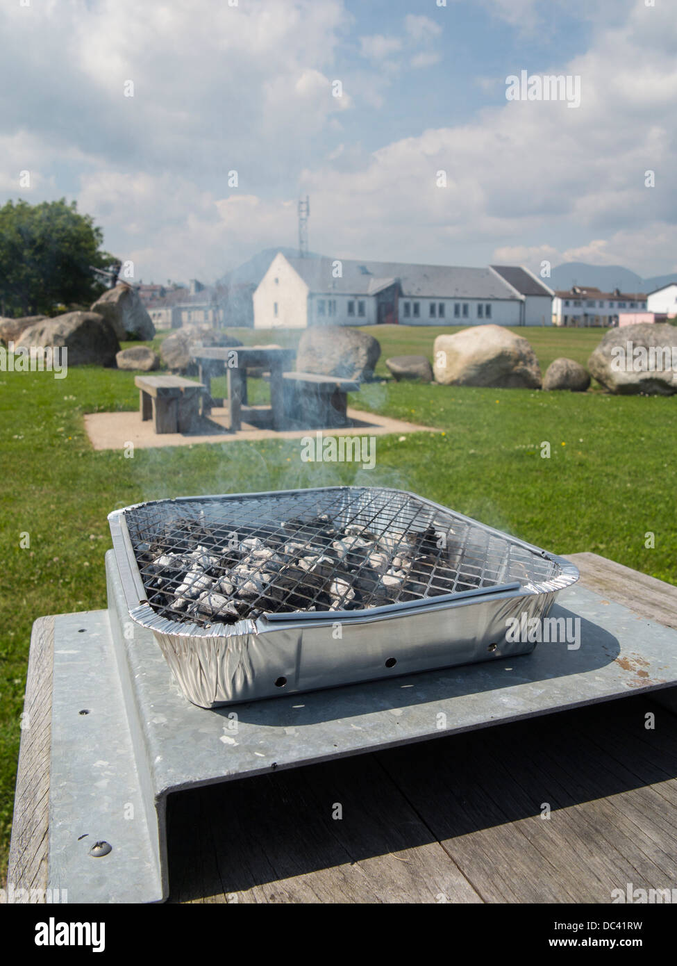 ein kleines wegwerfen Bbq beleuchtet und bereit zum Garen Stockfoto