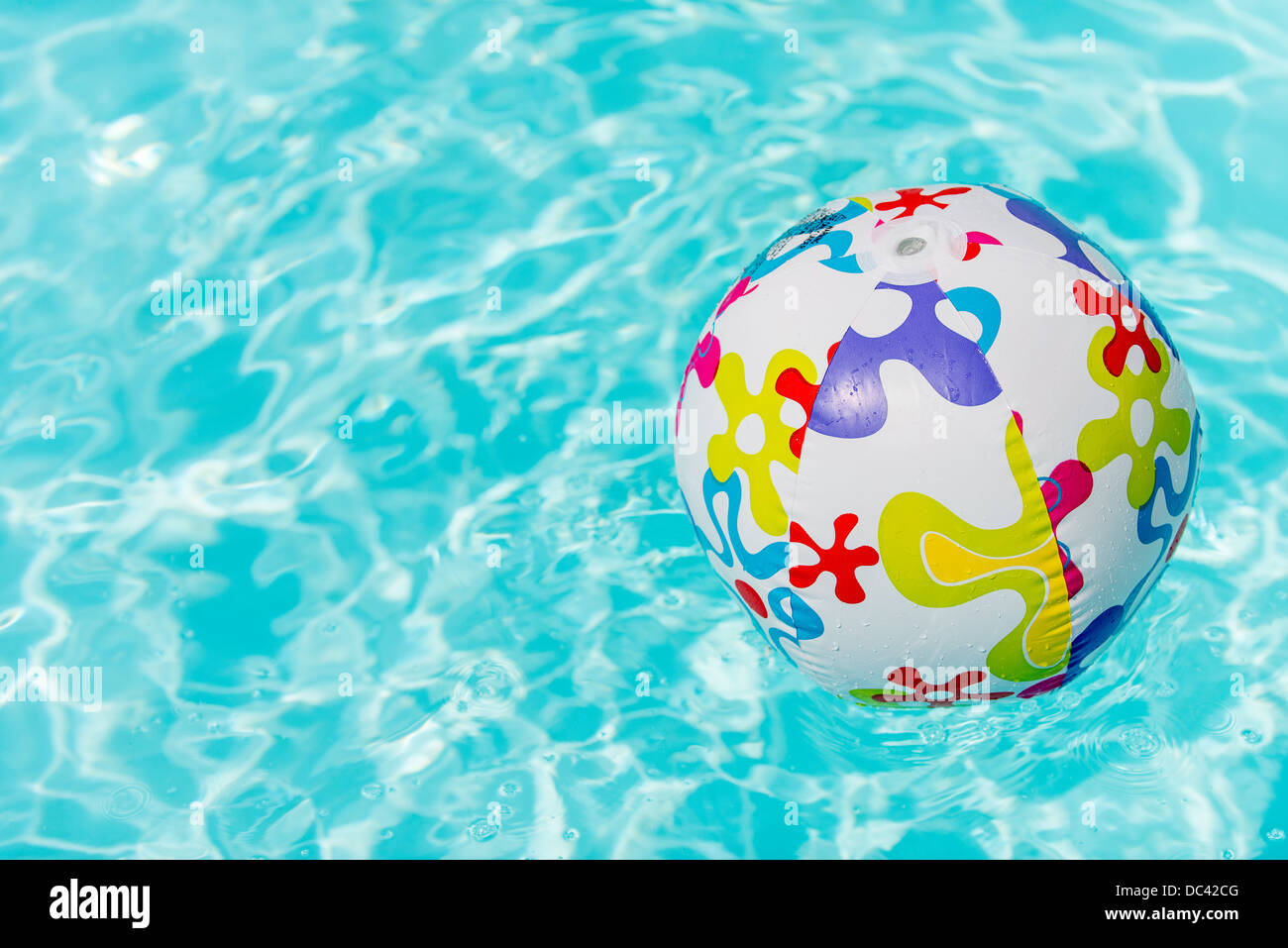 Bunte Beach-Ball schwimmt auf Wasser des Swimmingpools Stockfoto