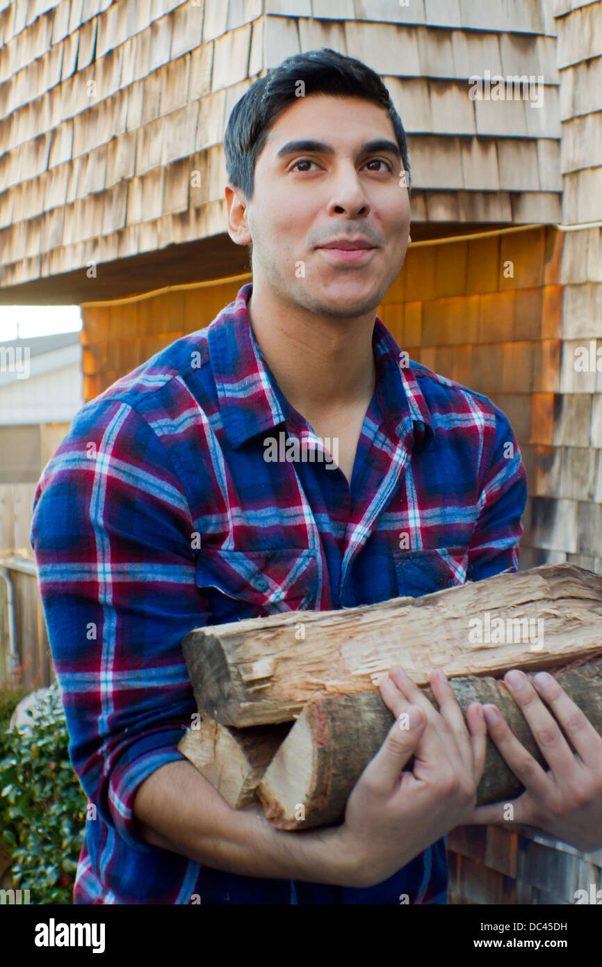 Ein Twety-etwas mexikanische Mann trägt Holz ein Zuhause. Stockfoto