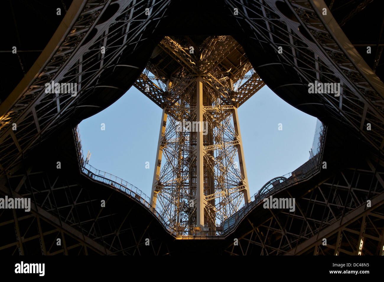 Blick nach oben durch die Mitte der Südpfeiler des Eiffelturms, Paris. Stockfoto