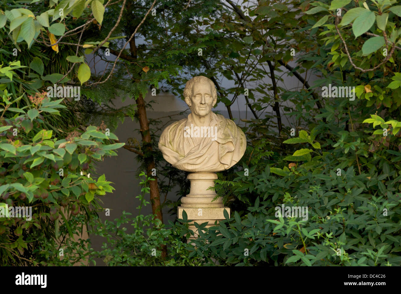 Versteckt unter dem Laub der quadratischen Honoré-Champion in Paris 6. Arrdt, die steinerne Büste von Montesquieu. Stockfoto