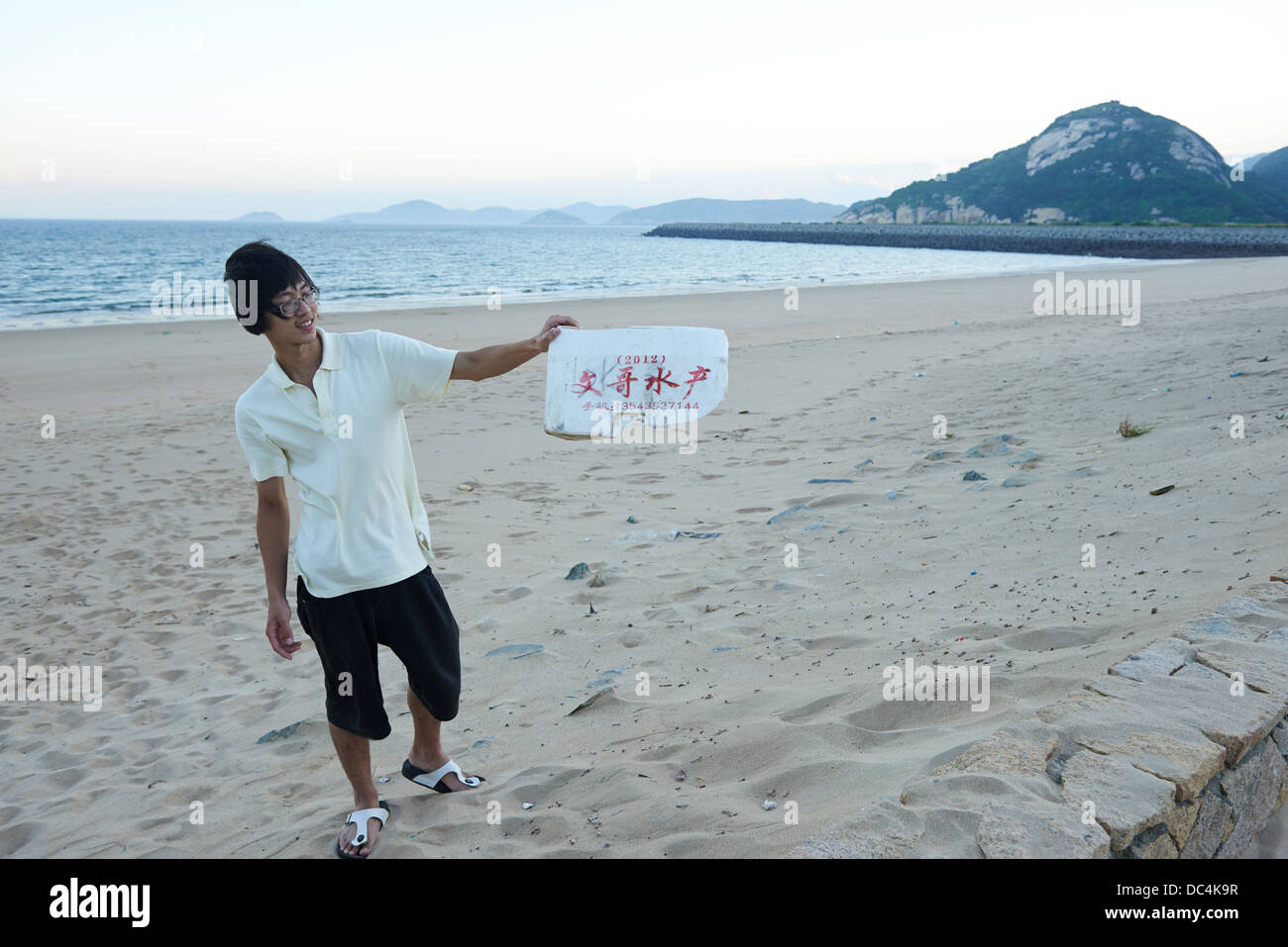 Ein ortsansässiger Beigan holt ein Stück chinesischen Festland Abfall, die ans Ufer gespült hat. Stockfoto