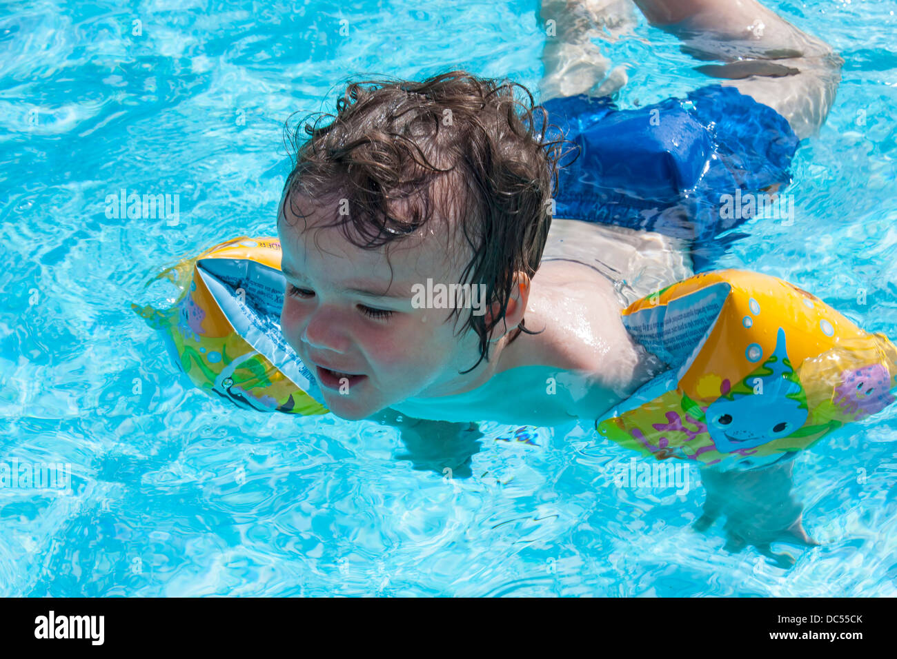 Junge, Schwimmen mit Armbinden Stockfoto