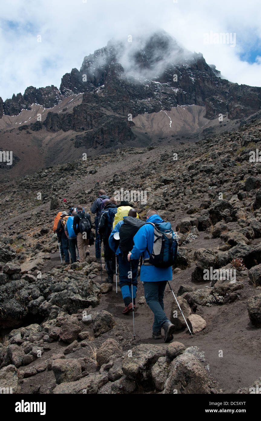 Eine Gruppe von Trekker, die ihren Weg durch die Lavafelder, am Mawenzi Tarn camp auf der Rongai route Stockfoto