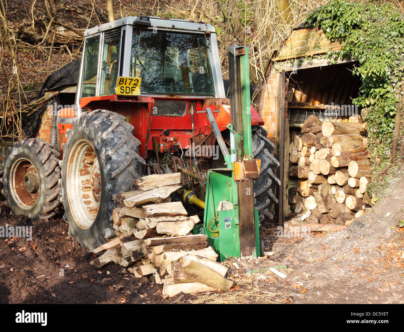 Traktor geparkt in Wäldern mit hydraulischen Anlage zum Spalten von Protokollen Stockfoto