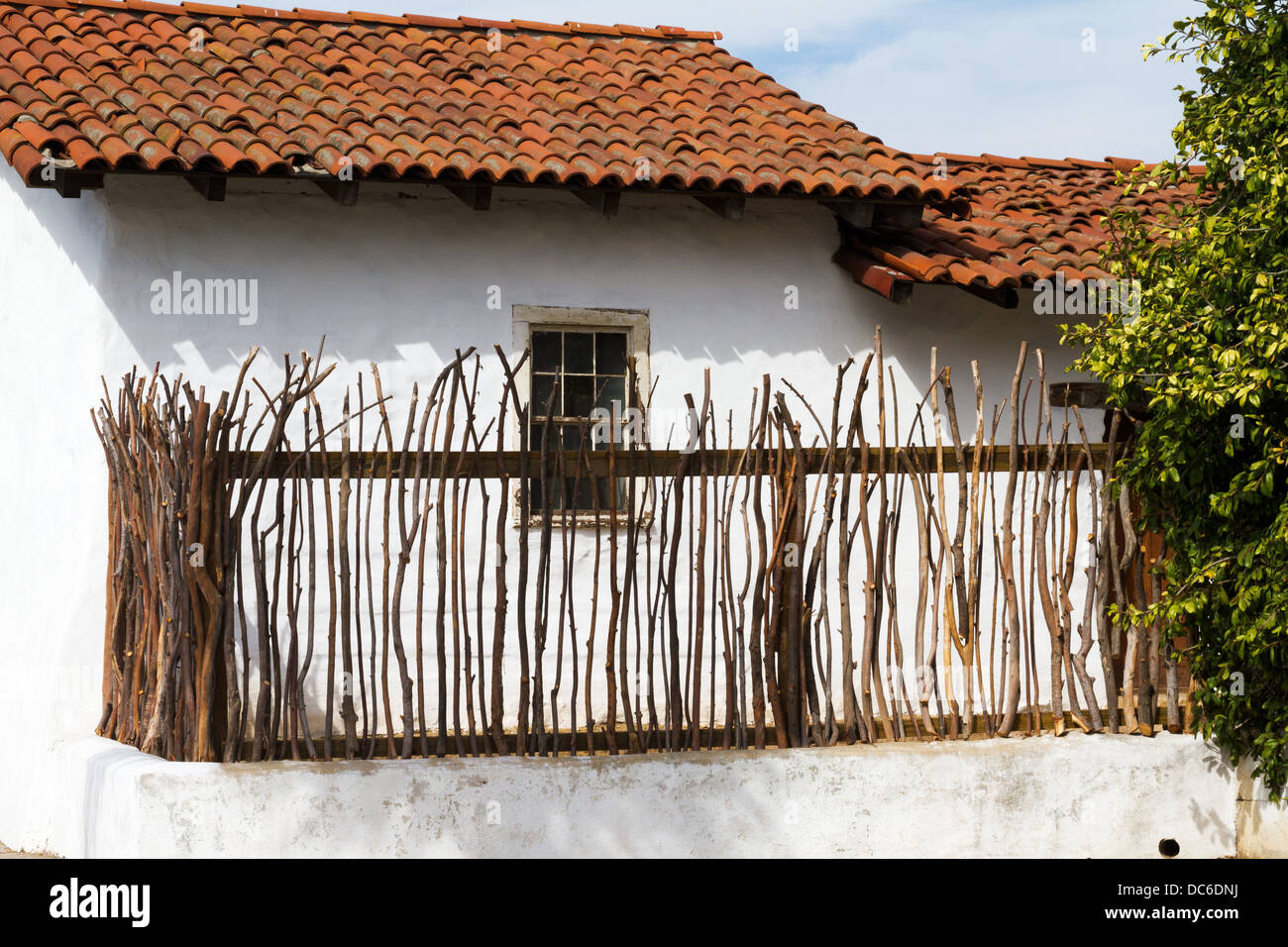 Außenansicht eines historischen frühen California House mit einem rustikalen Lattenzaun und rotes Ziegeldach. Stockfoto
