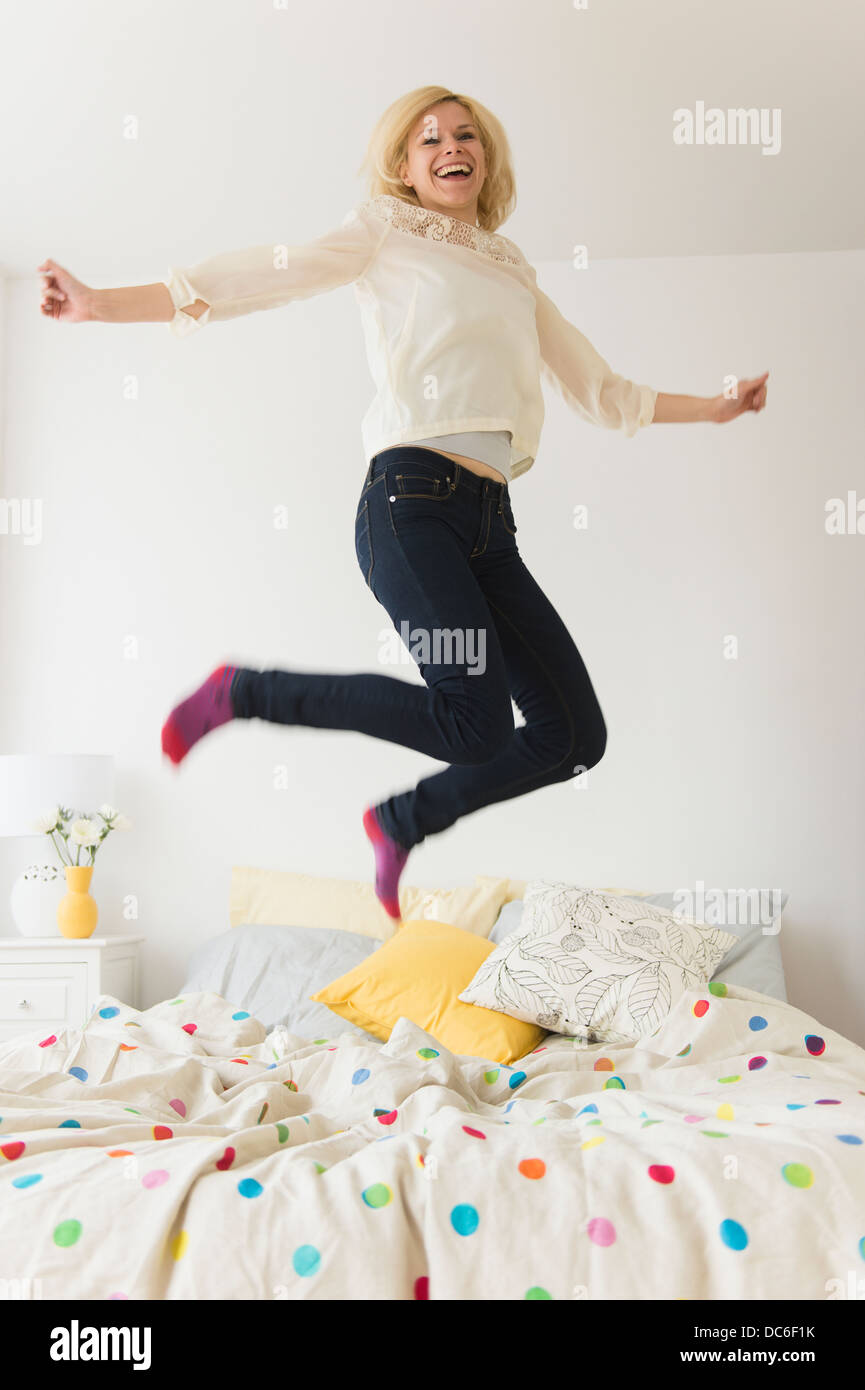 Junge Frau auf Bett springen Stockfoto