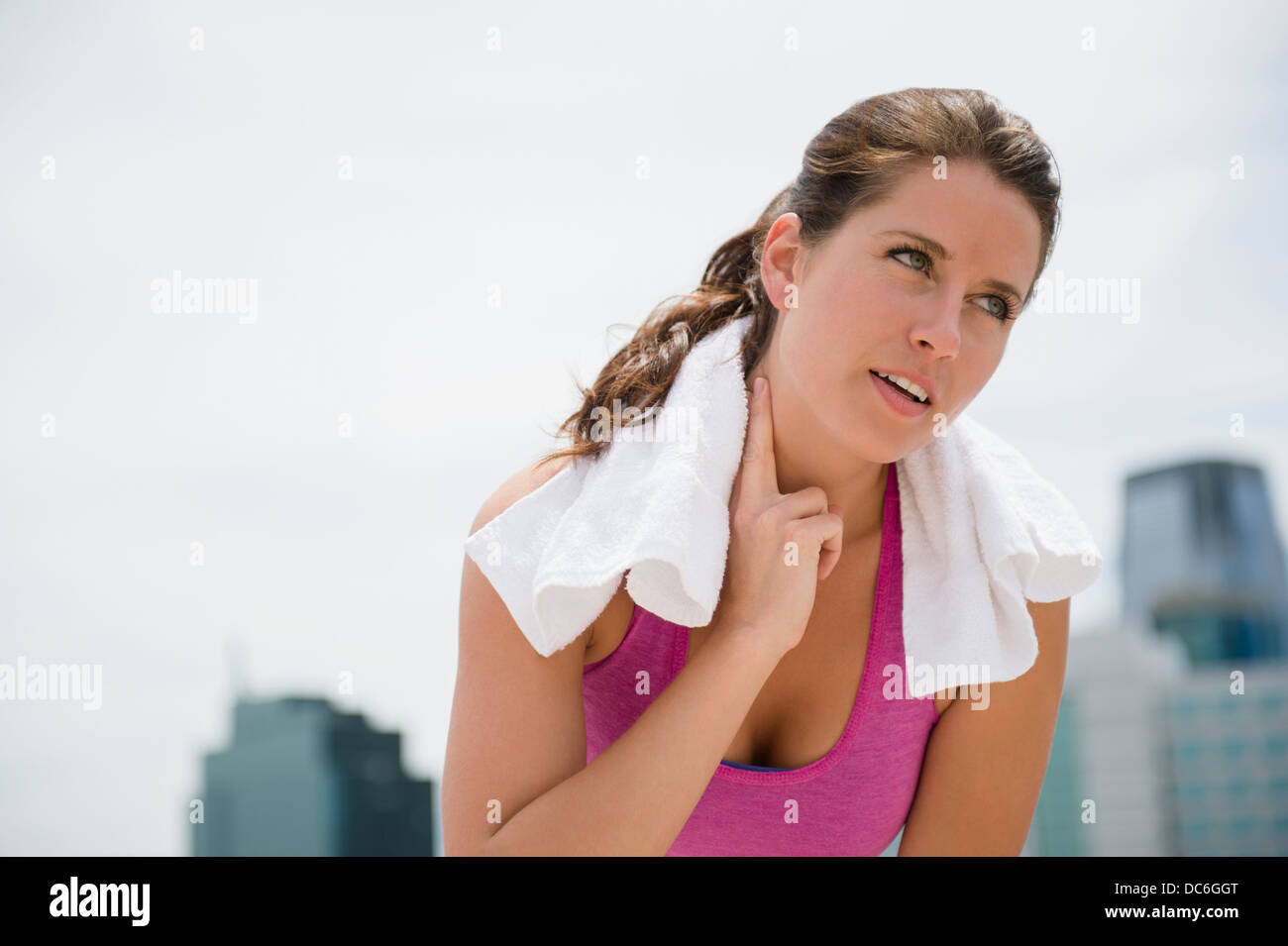 USA, New Jersey, Jersey City, Porträt der jungen Frau, die ihren Puls überprüfen Stockfoto