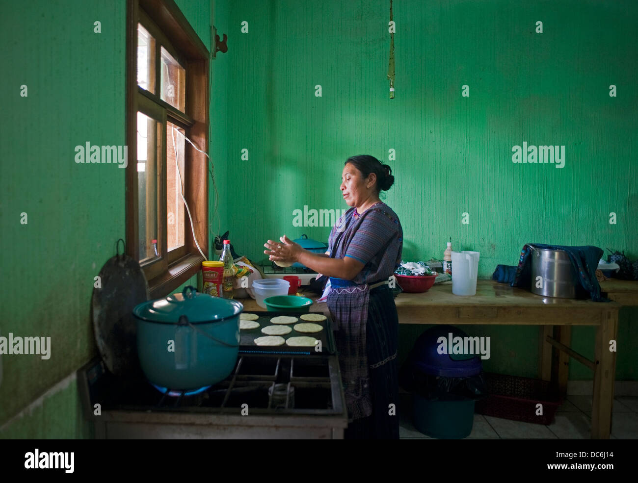 Traaditional Kleider indigene Frau namens Guipil und Corte bereitet Tortillas in San Antonio Palolo, Solola in Guatemala. Stockfoto