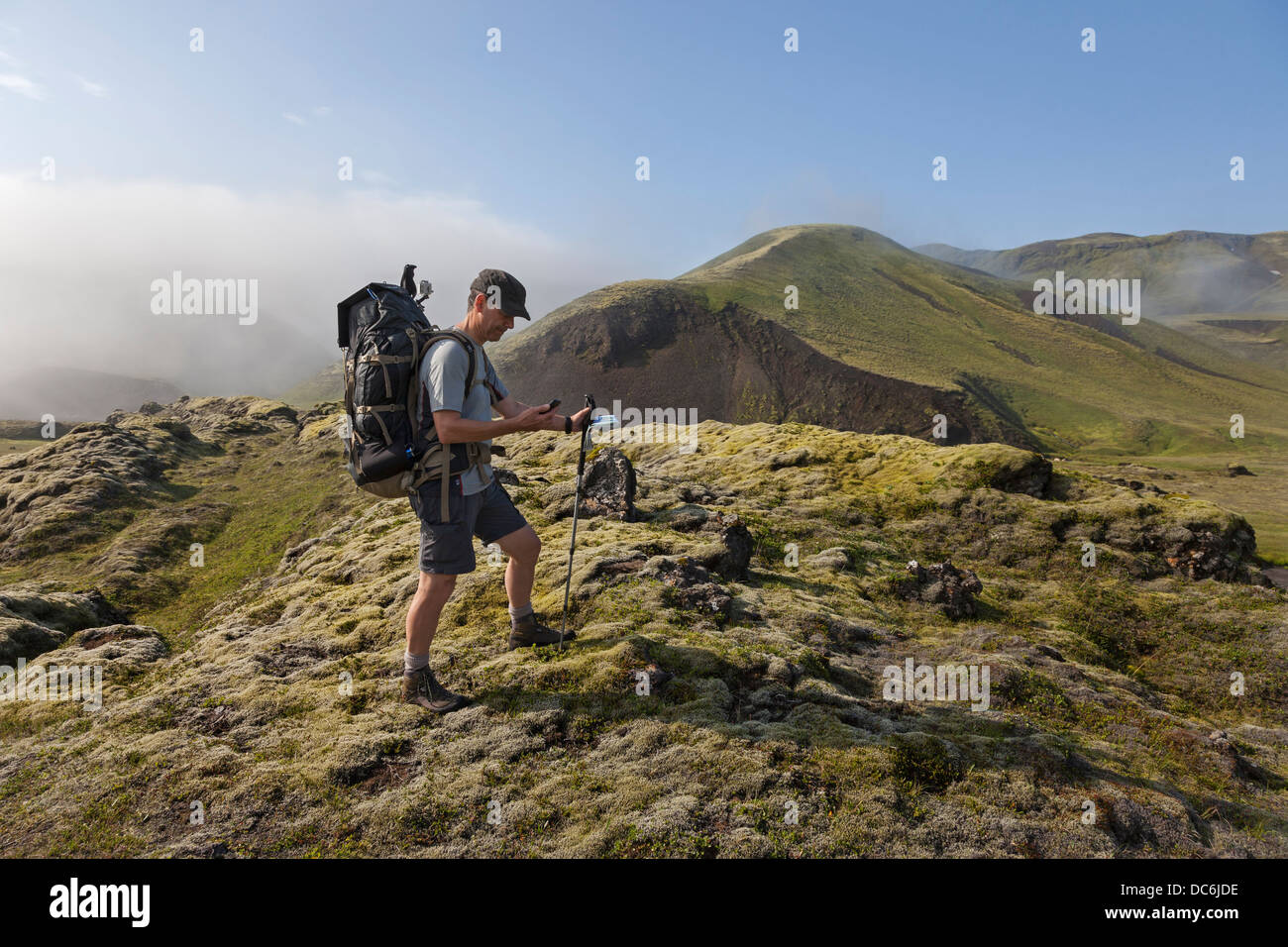 Wanderer mit Smartphone beim Wandern in Island Stockfoto