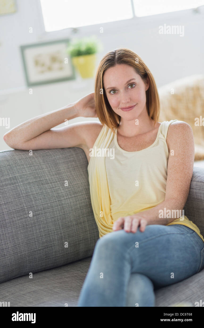 Porträt der jungen Frau auf dem Sofa entspannen Stockfoto