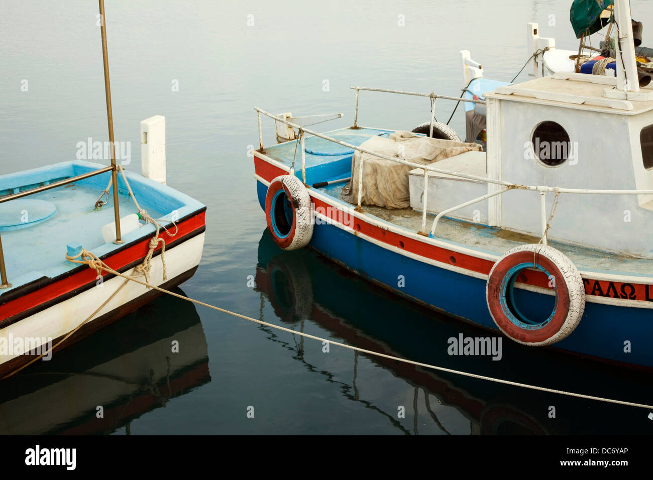 Bunte Fischerboote bei Sonnenuntergang in einem Hafen am McKenzie Strand in Larnaka, Zypern. Stockfoto