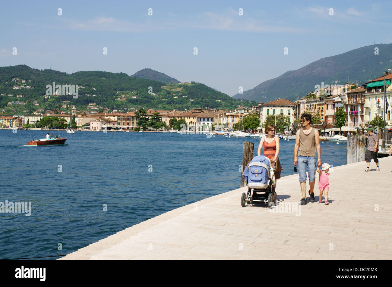 Junge Familie zu Fuß entlang der Promenade neben dem Gardasee in Salo, Italien, Europa Stockfoto