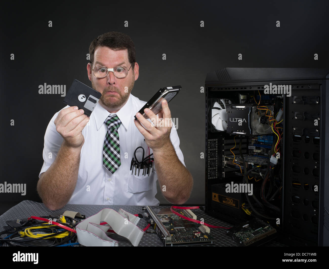 Mann mit Computer und verschiedenen Hardware-Komponenten Stockfoto