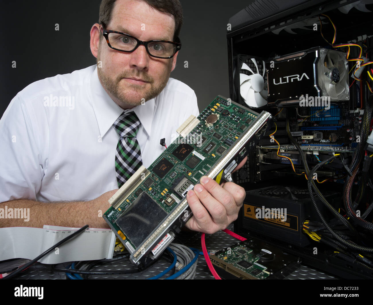 Mann mit Computer und verschiedenen Hardware-Komponenten Stockfoto